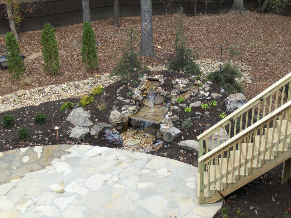 Photo of a large traditional backyard garden in Atlanta with a fire feature and natural stone pavers.
