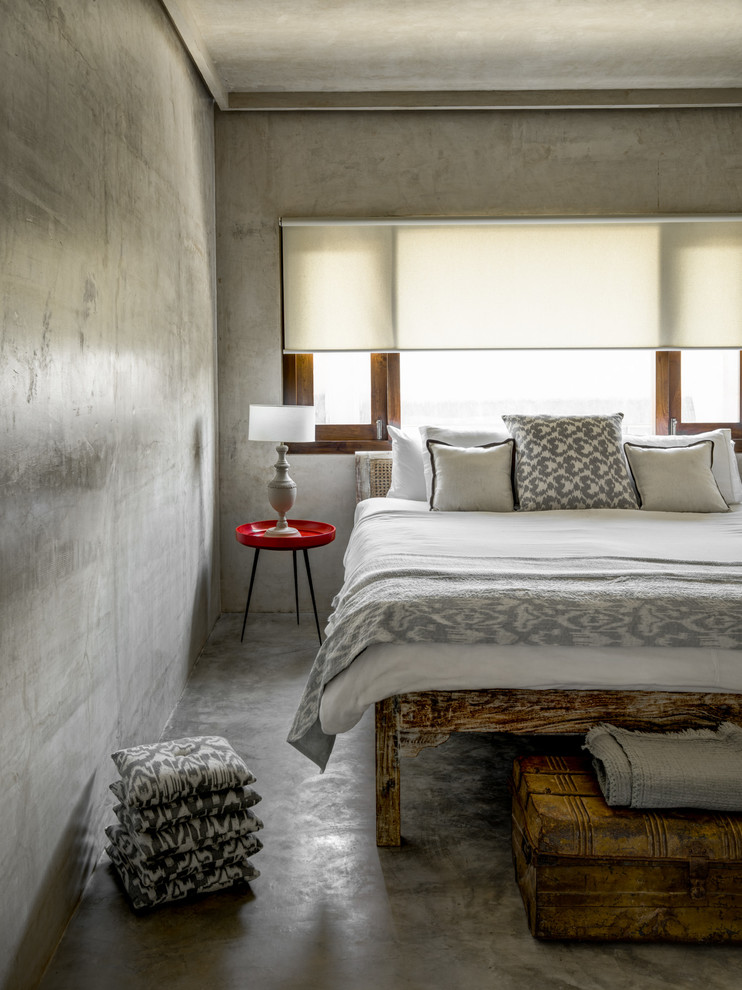 Mediterranean bedroom in Mumbai with grey walls and concrete floors.
