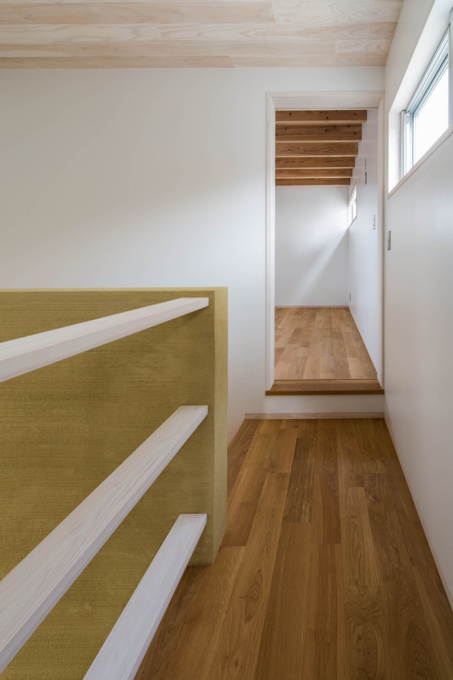 На фото: большой коридор в стиле модернизм с белыми стенами, светлым паркетным полом, коричневым полом и деревянным потолком