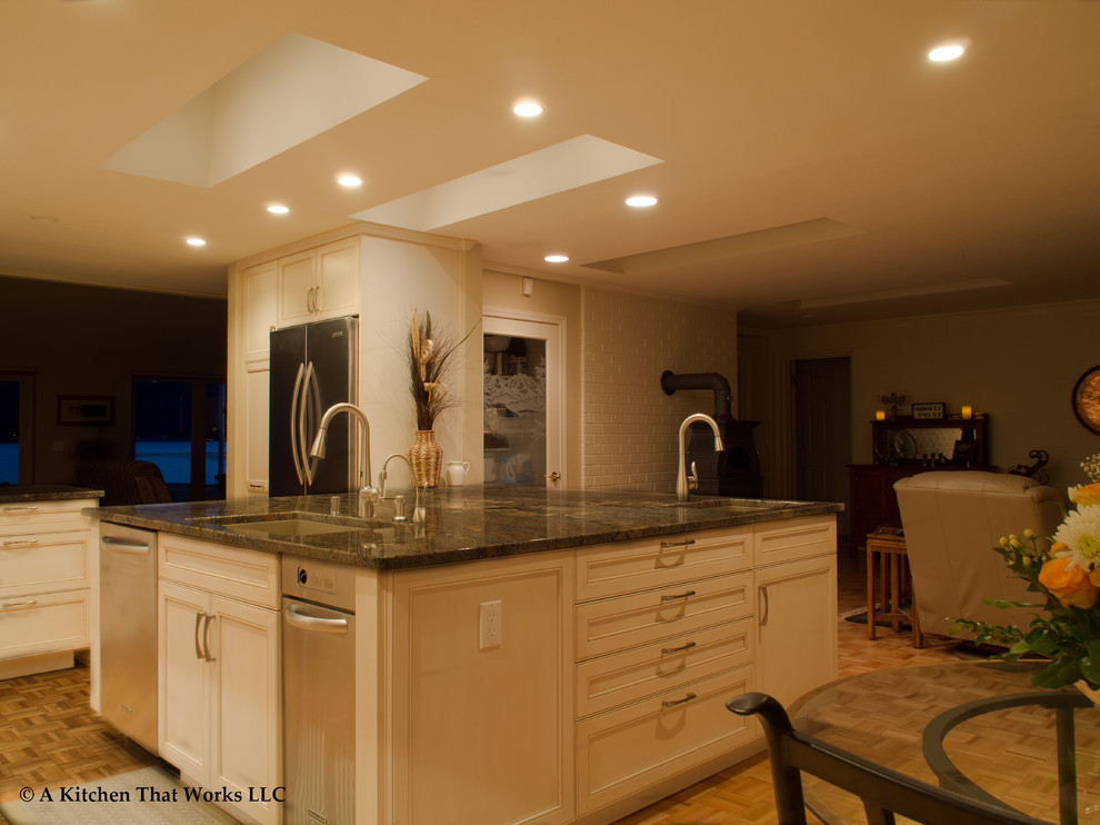 Example of a large transitional u-shaped medium tone wood floor and brown floor eat-in kitchen design in Seattle with an undermount sink, recessed-panel cabinets, white cabinets, granite countertops, stone slab backsplash, stainless steel appliances, an island, brown backsplash and brown countertops