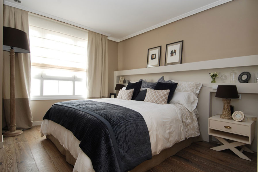 This is an example of a transitional master bedroom in Bilbao with beige walls and dark hardwood floors.