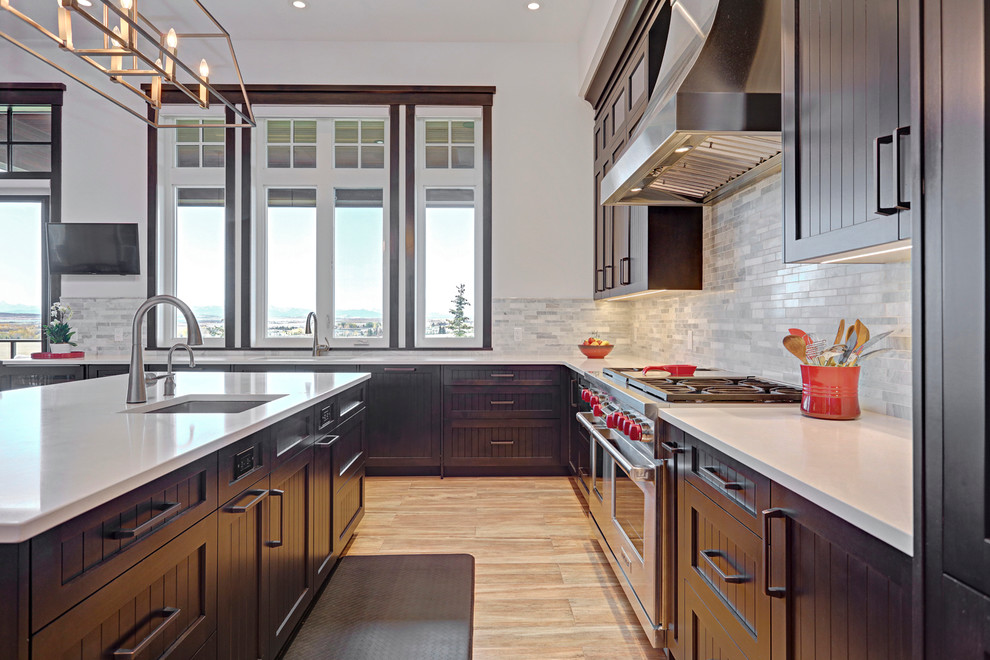 Inspiration for a transitional porcelain tile kitchen remodel in Calgary with an undermount sink, shaker cabinets, dark wood cabinets, quartzite countertops, multicolored backsplash, stainless steel appliances and an island