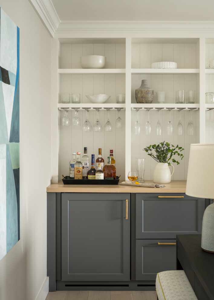 Ejemplo de bar en casa lineal costero pequeño sin pila con armarios estilo shaker, encimera de madera y suelo de madera clara