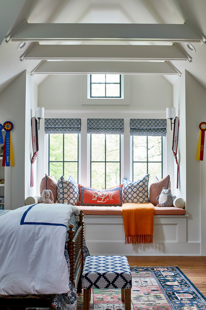 This is an example of a country gender-neutral kids' bedroom for kids 4-10 years old in Atlanta with white walls, medium hardwood floors and brown floor.