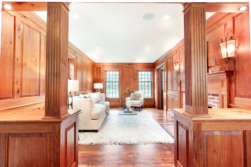 Стильный дизайн: парадная, изолированная гостиная комната среднего размера в стиле рустика с паркетным полом среднего тона, стандартным камином, фасадом камина из кирпича и деревянными стенами - последний тренд