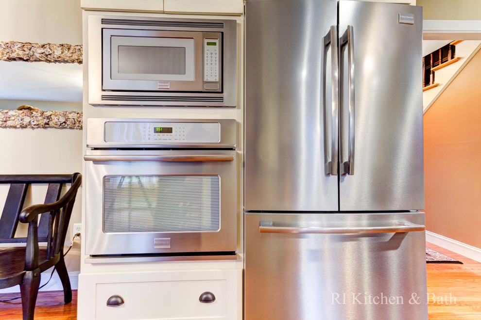 Large transitional u-shaped light wood floor eat-in kitchen photo in Providence with an undermount sink, shaker cabinets, beige cabinets, granite countertops, brown backsplash, porcelain backsplash, stainless steel appliances and an island