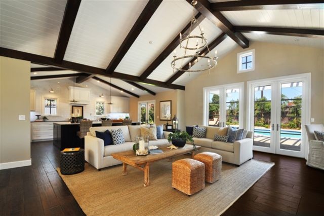 This is an example of a large beach style open concept family room in Los Angeles with beige walls and dark hardwood floors.