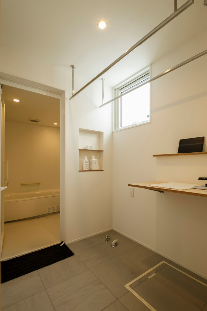 Foto på en mellanstor industriell bruna linjär tvättstuga enbart för tvätt, med träbänkskiva, vita väggar, linoleumgolv och grått golv