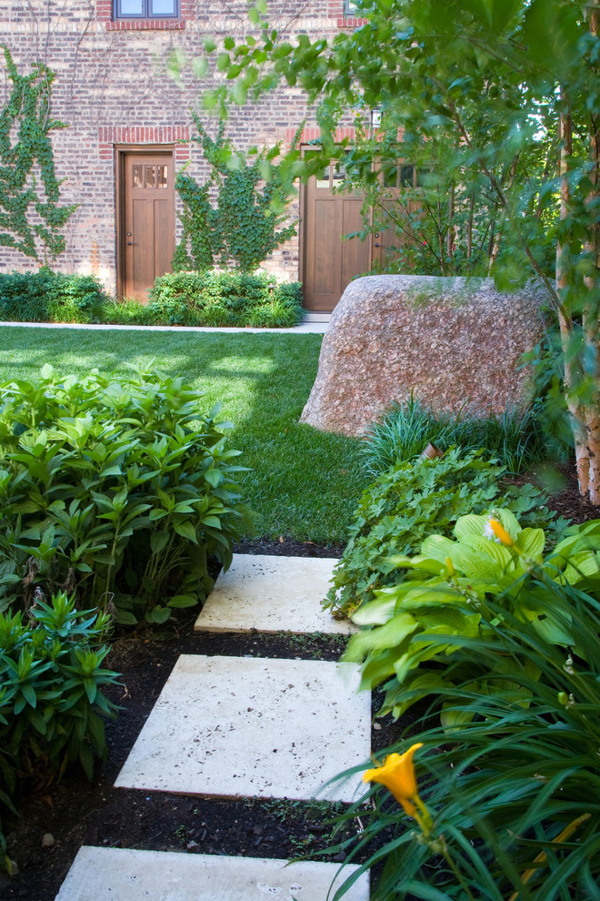 Cette image montre un petit jardin sur cour design avec des pavés en pierre naturelle.