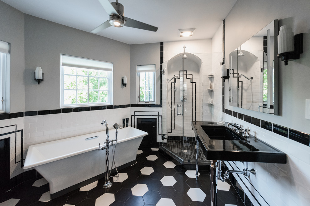 Inspiration for a large transitional master bathroom in Providence with open cabinets, a freestanding tub, a corner shower, a two-piece toilet, black and white tile, ceramic tile, grey walls, porcelain floors, a console sink, black floor, a hinged shower door and black benchtops.