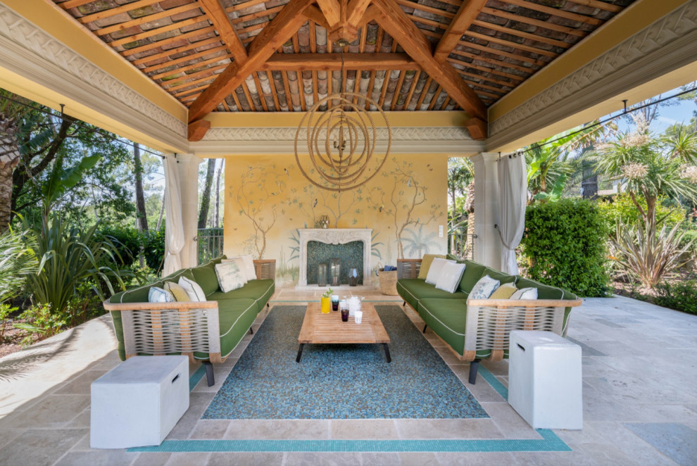 Immagine di un ampio patio o portico mediterraneo dietro casa con un caminetto e una pergola