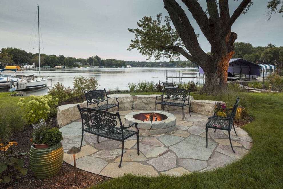 This is an example of a mid-sized traditional backyard patio in Minneapolis with a fire feature and brick pavers.