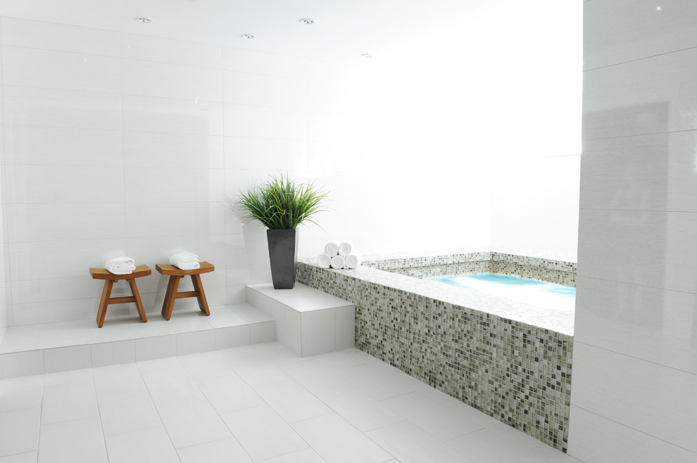 Design ideas for a mid-sized transitional bathroom in Vancouver with a drop-in tub, multi-coloured tile, glass sheet wall, grey walls, porcelain floors and with a sauna.
