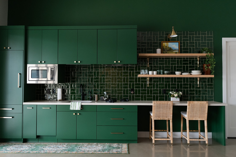 Small trendy single-wall concrete floor kitchen photo in Houston with a single-bowl sink, flat-panel cabinets, green cabinets, green backsplash, subway tile backsplash and paneled appliances