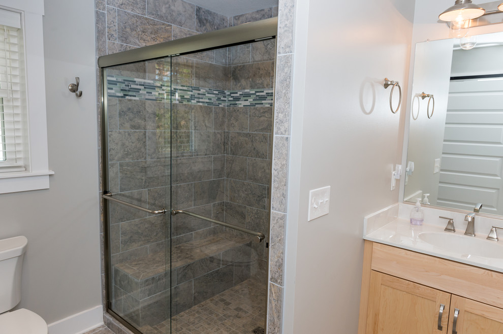 Alcove shower - mid-sized transitional 3/4 brown tile and porcelain tile alcove shower idea with shaker cabinets, light wood cabinets, a two-piece toilet, gray walls and an integrated sink