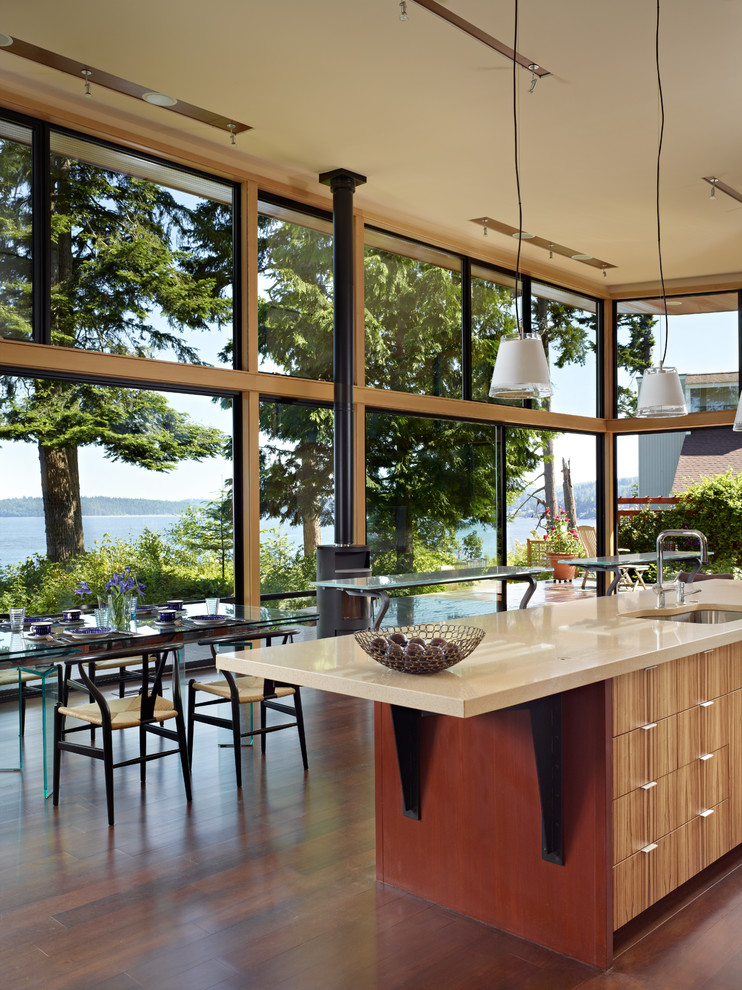 This is an example of a modern eat-in kitchen in Seattle with a single-bowl sink, flat-panel cabinets, medium wood cabinets and quartz benchtops.