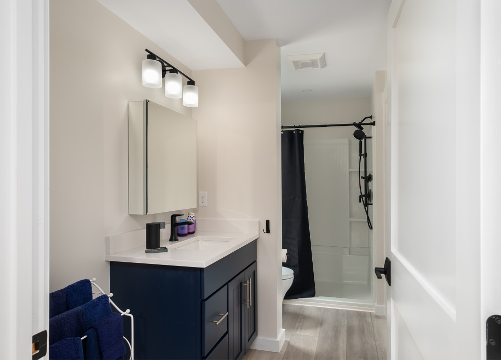 Idéer för att renovera ett mellanstort funkis badrum med dusch, med skåp i shakerstil, blå skåp, en kantlös dusch, vinylgolv, ett undermonterad handfat, bänkskiva i akrylsten och dusch med duschdraperi