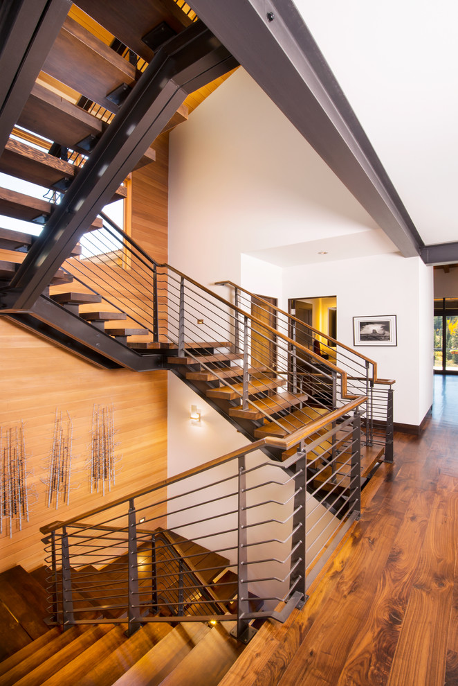 Photo of a large contemporary wood u-shaped staircase in Denver with open risers and mixed railing.