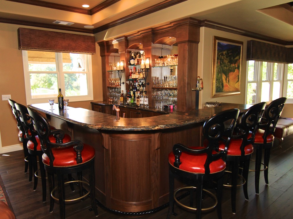 Inspiration for a large country l-shaped seated home bar in Sacramento with an undermount sink, dark wood cabinets, granite benchtops, multi-coloured splashback and medium hardwood floors.