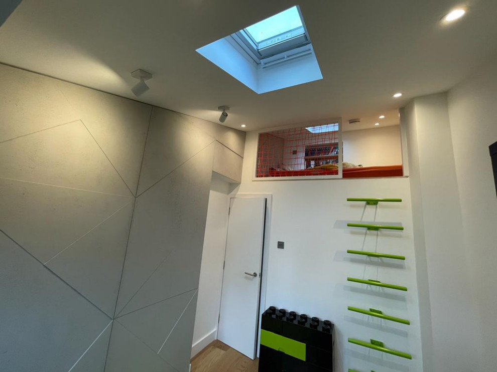 Immagine di una camera da letto stile loft design con pareti bianche, parquet chiaro, soffitto a volta e pannellatura