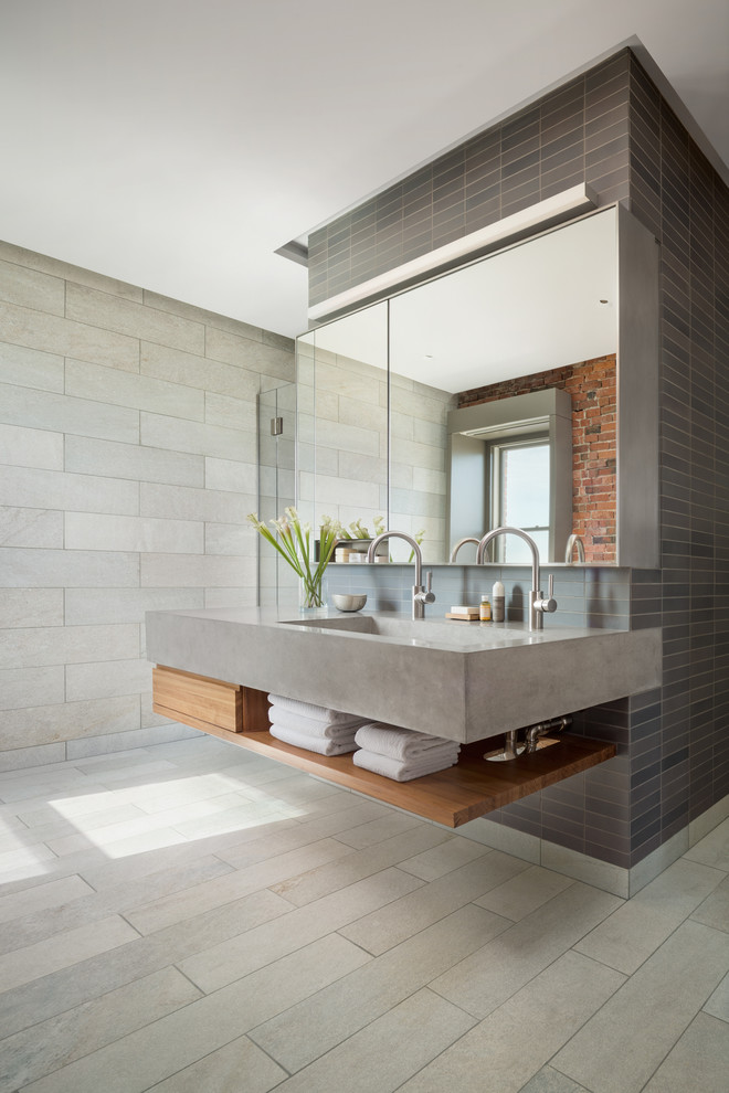 Industrial master bathroom in Boston with open cabinets, gray tile, grey walls, a trough sink, grey floor, grey benchtops and light wood cabinets.