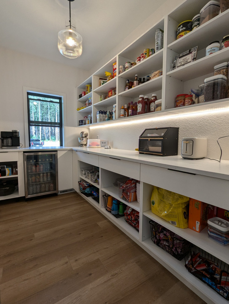Example of a large transitional l-shaped vinyl floor and brown floor eat-in kitchen design with a double-bowl sink, shaker cabinets, light wood cabinets, quartzite countertops, white backsplash, ceramic backsplash, stainless steel appliances, an island and white countertops