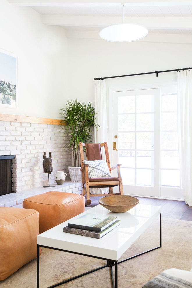 Inspiration for a mid-sized eclectic formal open concept living room in Los Angeles with white walls, medium hardwood floors, a corner fireplace, a brick fireplace surround, no tv and brown floor.