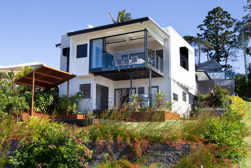 Inspiration for a contemporary two-storey white house exterior in Brisbane with a flat roof.