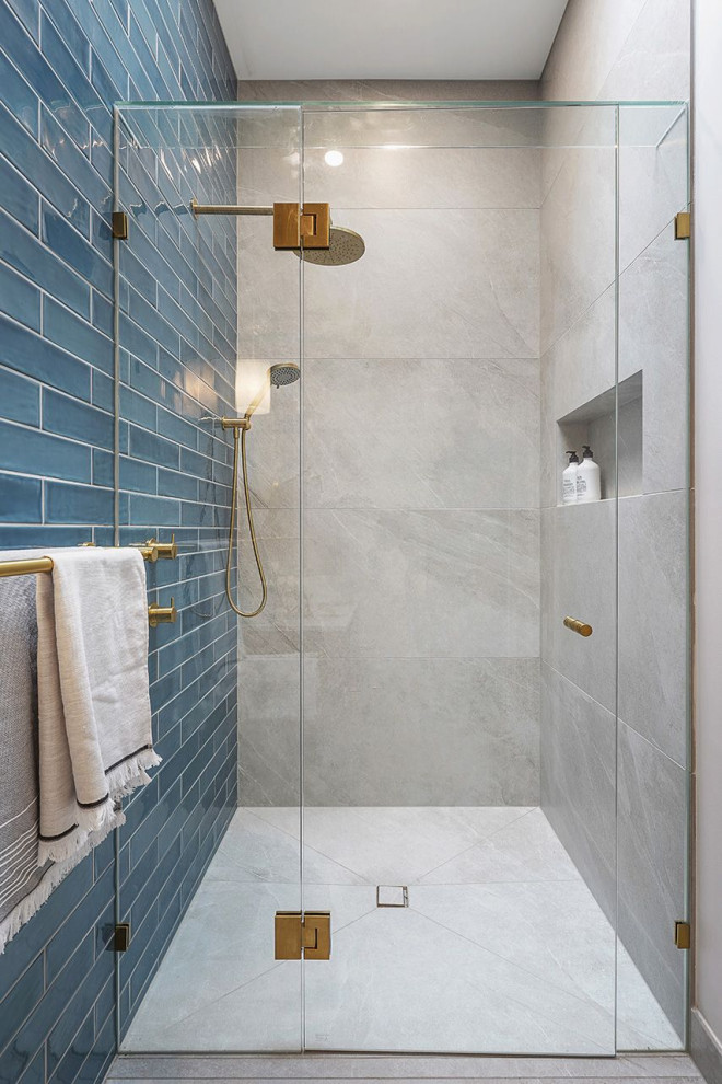 This is an example of a transitional 3/4 wet room bathroom in Melbourne with flat-panel cabinets, medium wood cabinets, a one-piece toilet, gray tile, porcelain tile, grey walls, porcelain floors, a vessel sink, terrazzo benchtops, grey floor, a hinged shower door, grey benchtops, a niche, a single vanity and a floating vanity.