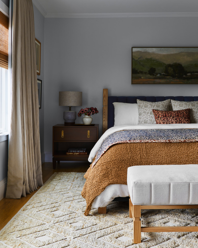 Foto di una camera da letto chic con pareti grigie, pavimento in legno massello medio e pavimento marrone