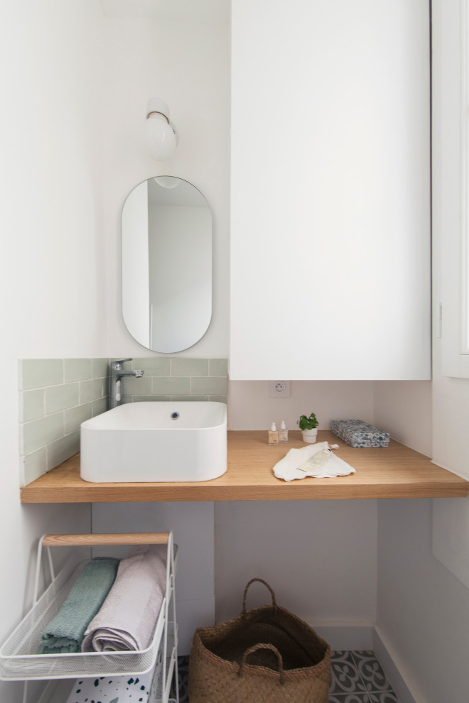 This is an example of a small 3/4 bathroom in Paris with a wall-mount toilet, green tile, subway tile, white walls, a console sink, wood benchtops, a hinged shower door and a single vanity.