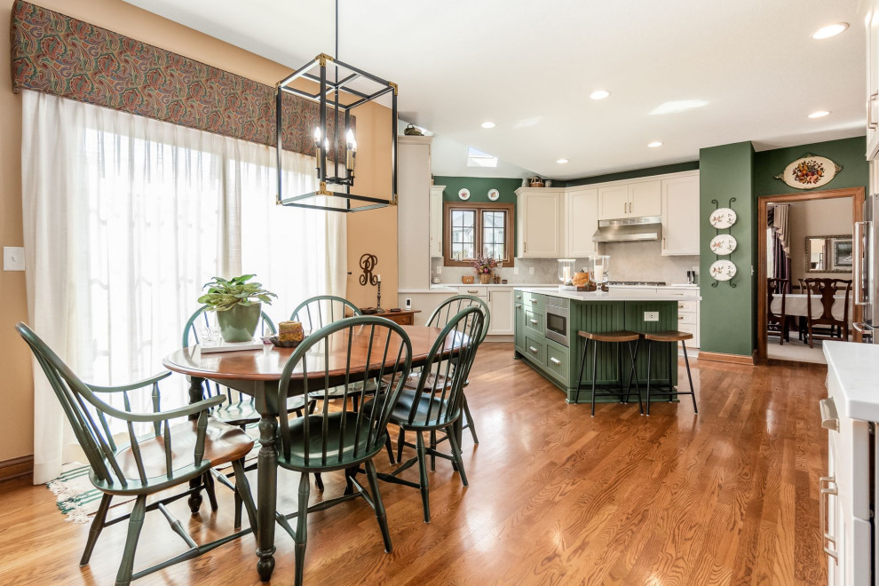 Inspiration for a transitional u-shaped medium tone wood floor and brown floor eat-in kitchen remodel in Columbus with a farmhouse sink, recessed-panel cabinets, white cabinets, quartzite countertops, beige backsplash, mosaic tile backsplash, stainless steel appliances, an island and white countertops