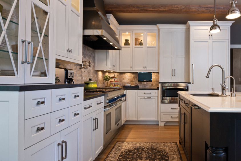 This is an example of a transitional l-shaped open plan kitchen in Minneapolis with an undermount sink, flat-panel cabinets, quartzite benchtops, grey splashback, stone tile splashback, stainless steel appliances, medium hardwood floors and with island.