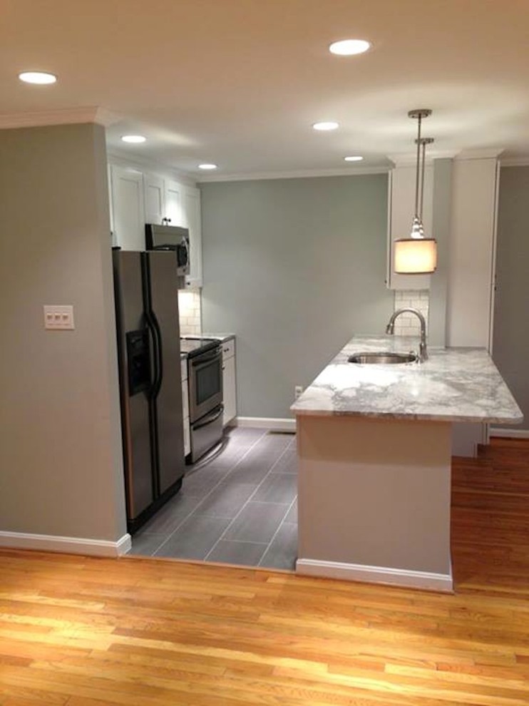 Eat-in kitchen - mid-sized traditional galley ceramic tile eat-in kitchen idea in DC Metro with an undermount sink, shaker cabinets, white cabinets, granite countertops, white backsplash, subway tile backsplash, stainless steel appliances, green walls and a peninsula
