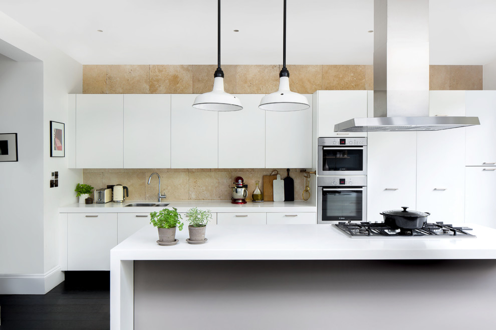Mid-sized contemporary galley kitchen in Hamburg with dark hardwood floors, flat-panel cabinets, white cabinets, beige splashback, stainless steel appliances, with island, white benchtop, a double-bowl sink and black floor.