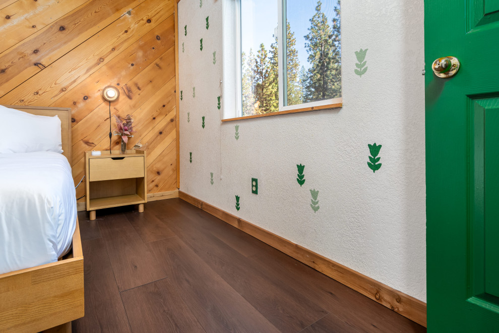 Mittelgroßes Stilmix Hauptschlafzimmer mit brauner Wandfarbe, Vinylboden, Kaminofen, Kaminumrandung aus Backstein, braunem Boden und freigelegten Dachbalken in Sacramento