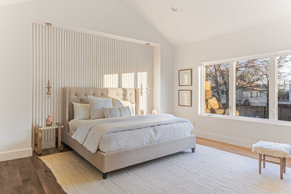 Design ideas for a large beach style master bedroom in Dallas with white walls, light hardwood floors, brown floor, vaulted and panelled walls.