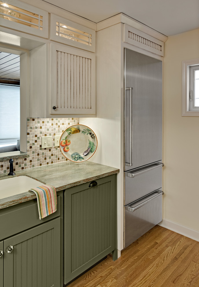 Small country galley kitchen in Minneapolis with an integrated sink, shaker cabinets, white cabinets, solid surface benchtops, multi-coloured splashback, glass tile splashback, stainless steel appliances, light hardwood floors and no island.