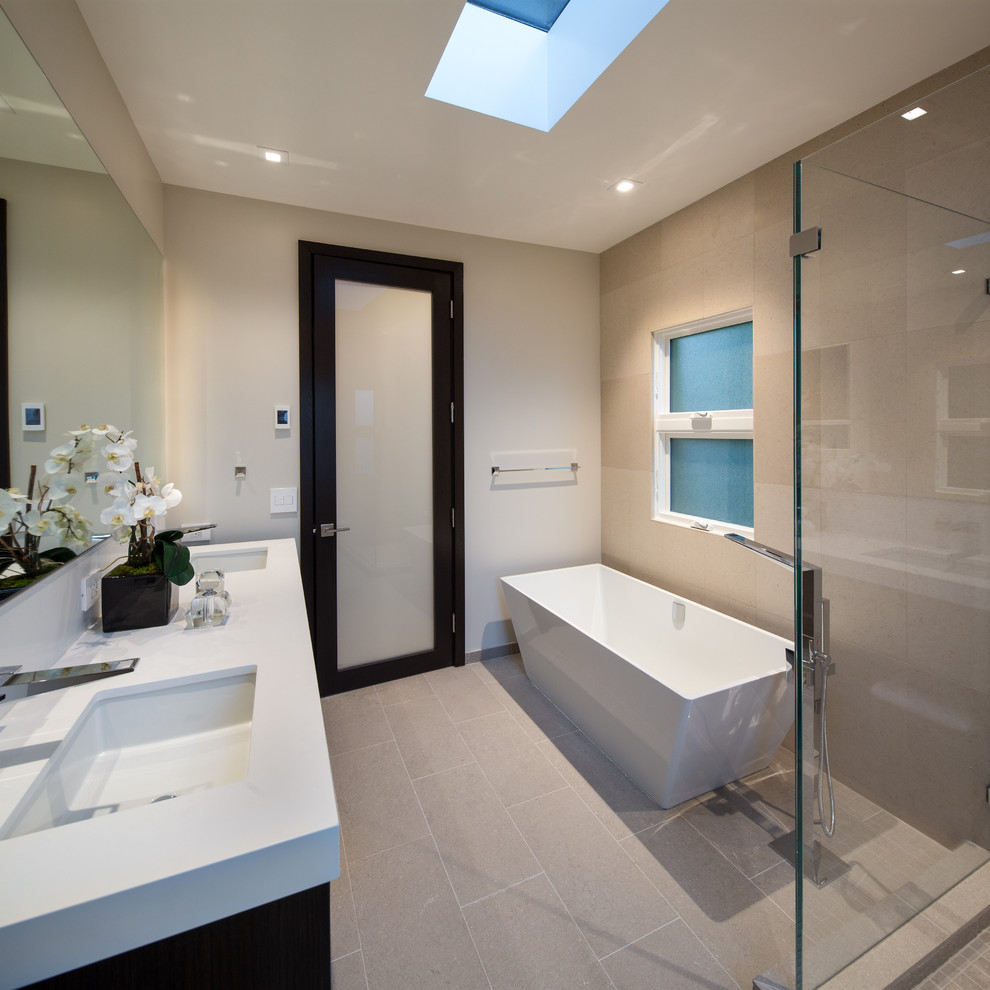 Mid-sized contemporary master bathroom in San Francisco with flat-panel cabinets, dark wood cabinets, a corner shower, a one-piece toilet, beige tile, ceramic tile, white walls, an integrated sink, engineered quartz benchtops, a freestanding tub, porcelain floors, grey floor and a hinged shower door.