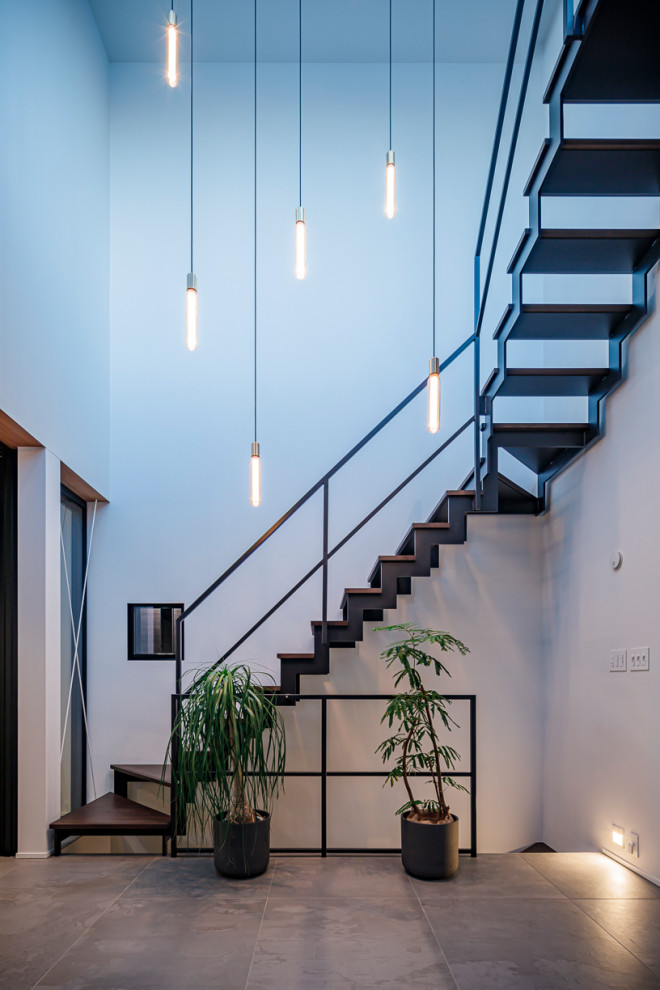 Ejemplo de escalera suspendida contemporánea grande sin contrahuella con escalones de madera, barandilla de metal y papel pintado