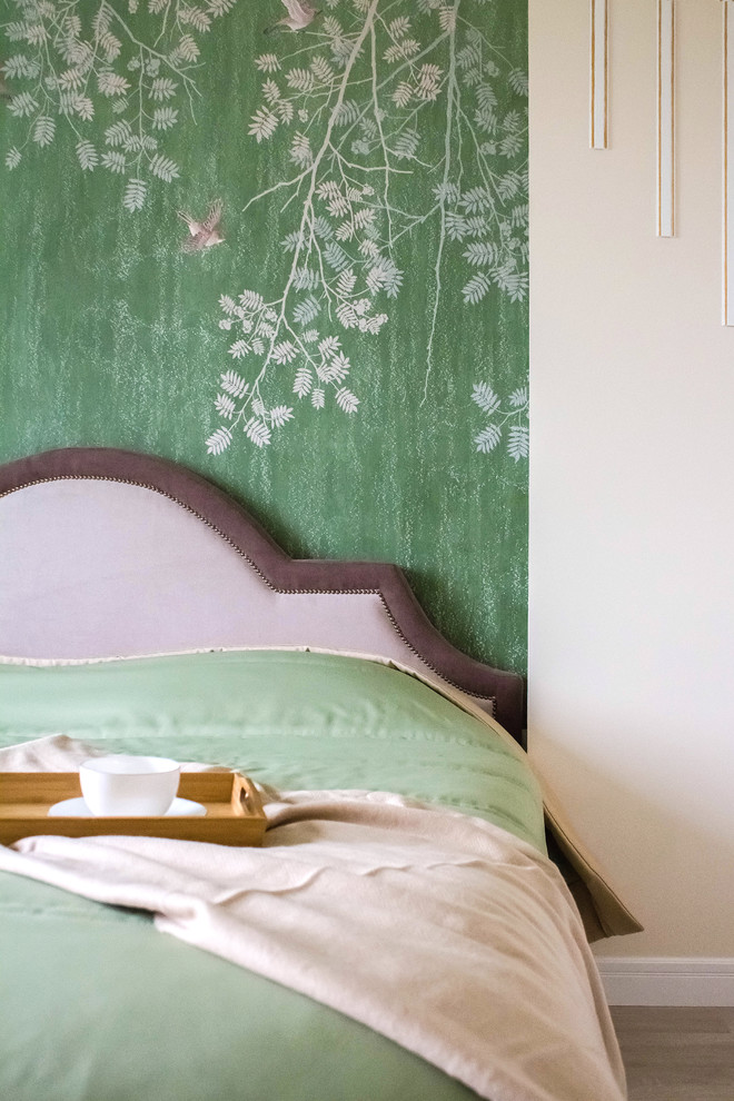 This is an example of a small transitional bedroom in Other with green walls, laminate floors and beige floor.
