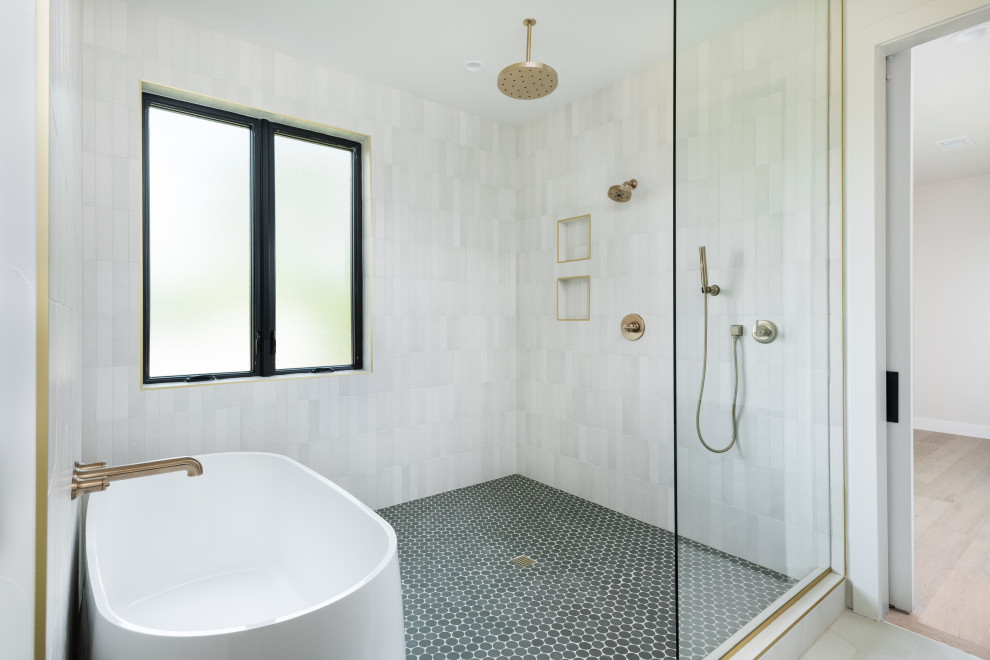 На фото: большая главная ванная комната в стиле неоклассика (современная классика) с отдельно стоящей ванной, душем над ванной, белой плиткой, керамической плиткой, белыми стенами, полом из керамогранита, зеленым полом, открытым душем и нишей