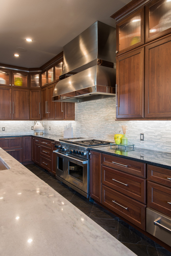 Large transitional u-shaped enclosed kitchen photo with an undermount sink, recessed-panel cabinets, medium tone wood cabinets, granite countertops, gray backsplash, stainless steel appliances and an island