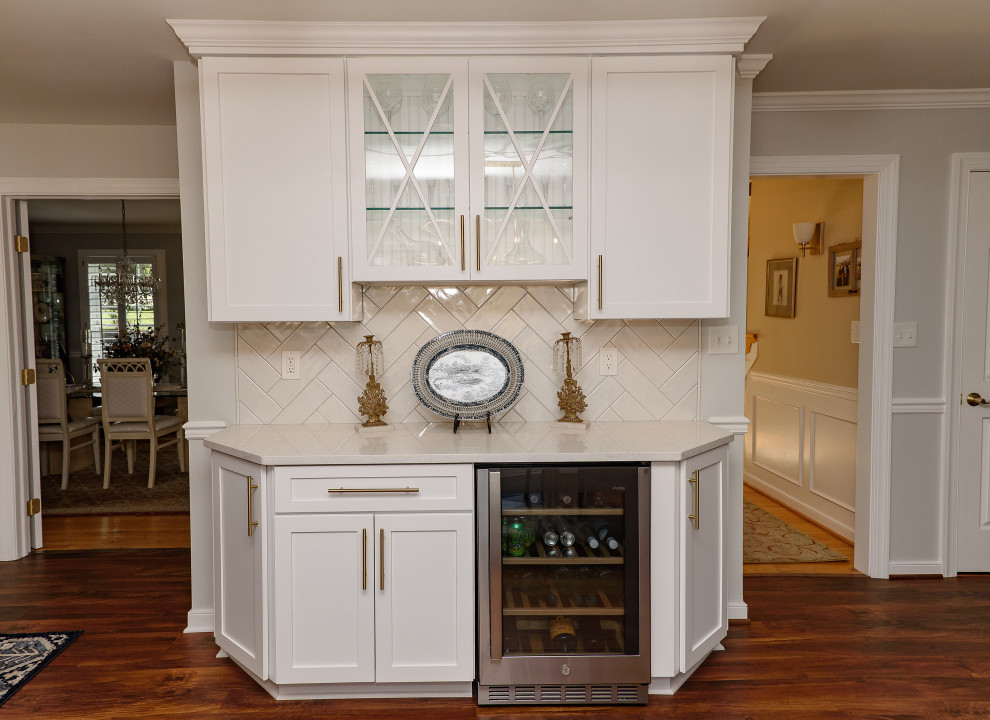 Exempel på ett mellanstort klassiskt vit vitt kök, med skåp i shakerstil, vita skåp, bänkskiva i kvarts, vitt stänkskydd, stänkskydd i tunnelbanekakel, rostfria vitvaror, en köksö, brunt golv, en undermonterad diskho och mellanmörkt trägolv