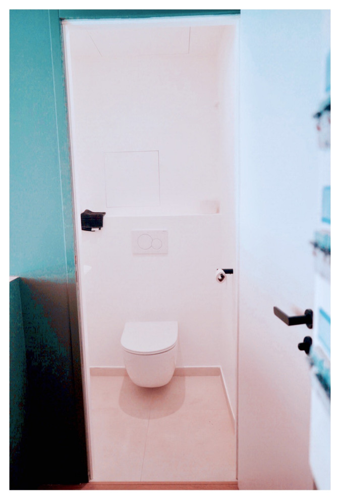 Photo of a small cloakroom in Lyon with a wall mounted toilet, white walls, light hardwood flooring, beige floors and brick walls.