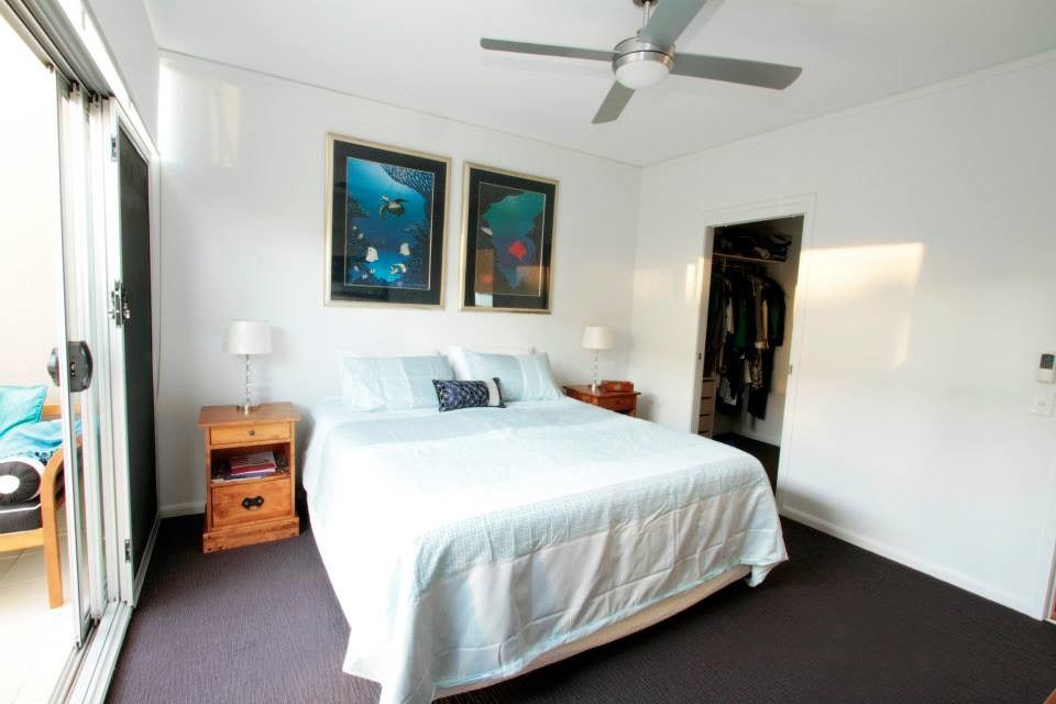 Mid-sized contemporary bedroom in Brisbane with white walls and carpet.
