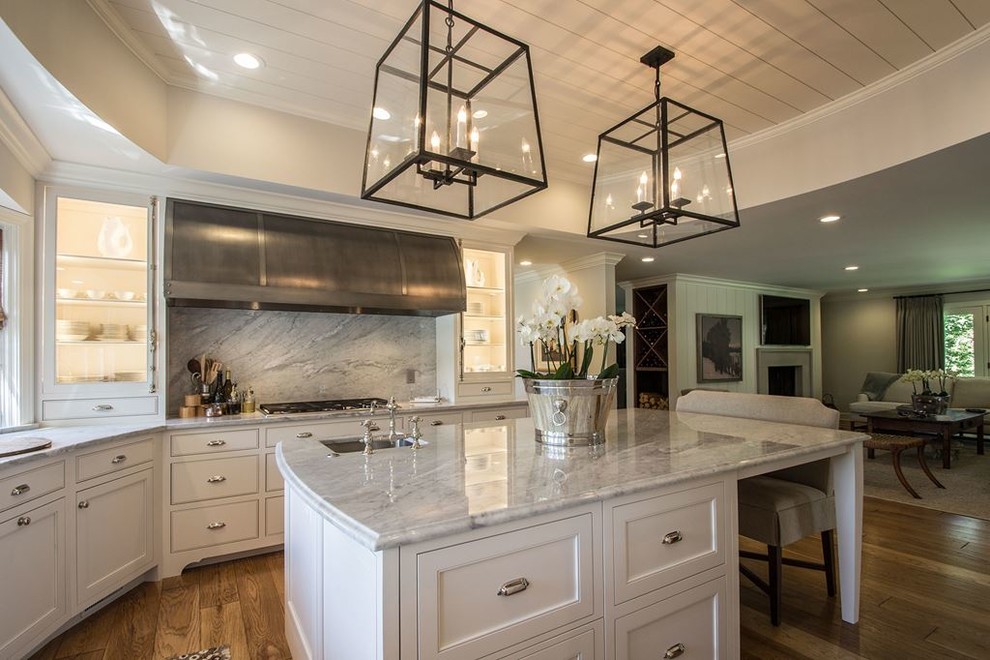 Inspiration for a large transitional l-shaped medium tone wood floor open concept kitchen remodel in Austin with shaker cabinets, white cabinets, marble countertops, multicolored backsplash, stone slab backsplash, stainless steel appliances, an island and a farmhouse sink