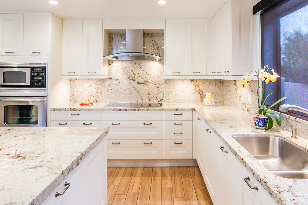 Example of a mid-sized transitional l-shaped ceramic tile enclosed kitchen design in San Francisco with a single-bowl sink, shaker cabinets, white cabinets, granite countertops, multicolored backsplash, stone slab backsplash, stainless steel appliances and an island