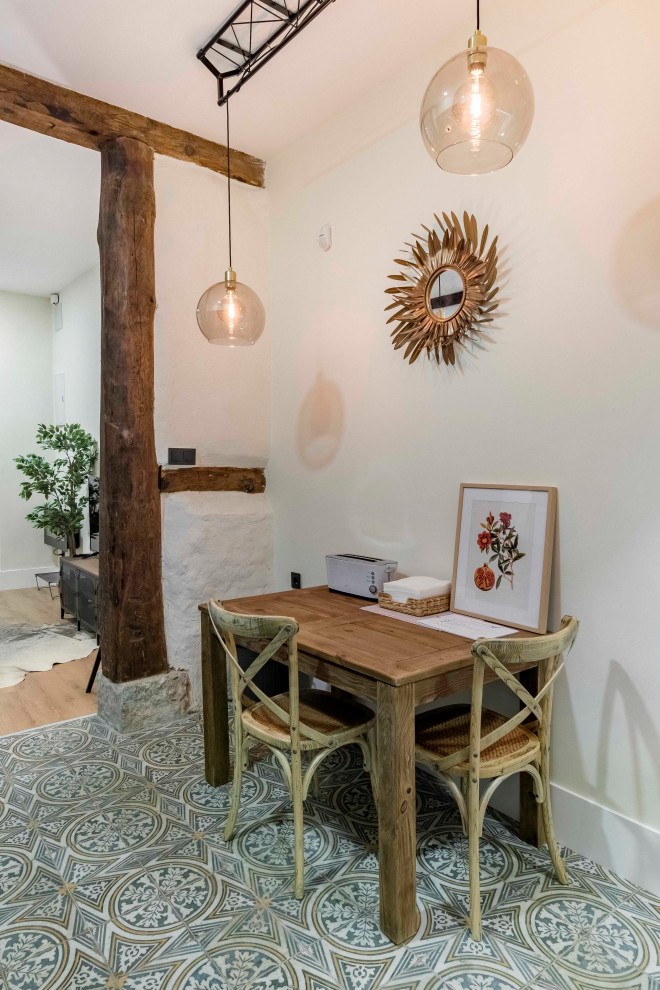 Diseño de comedor vintage pequeño abierto con suelo de baldosas de cerámica y vigas vistas