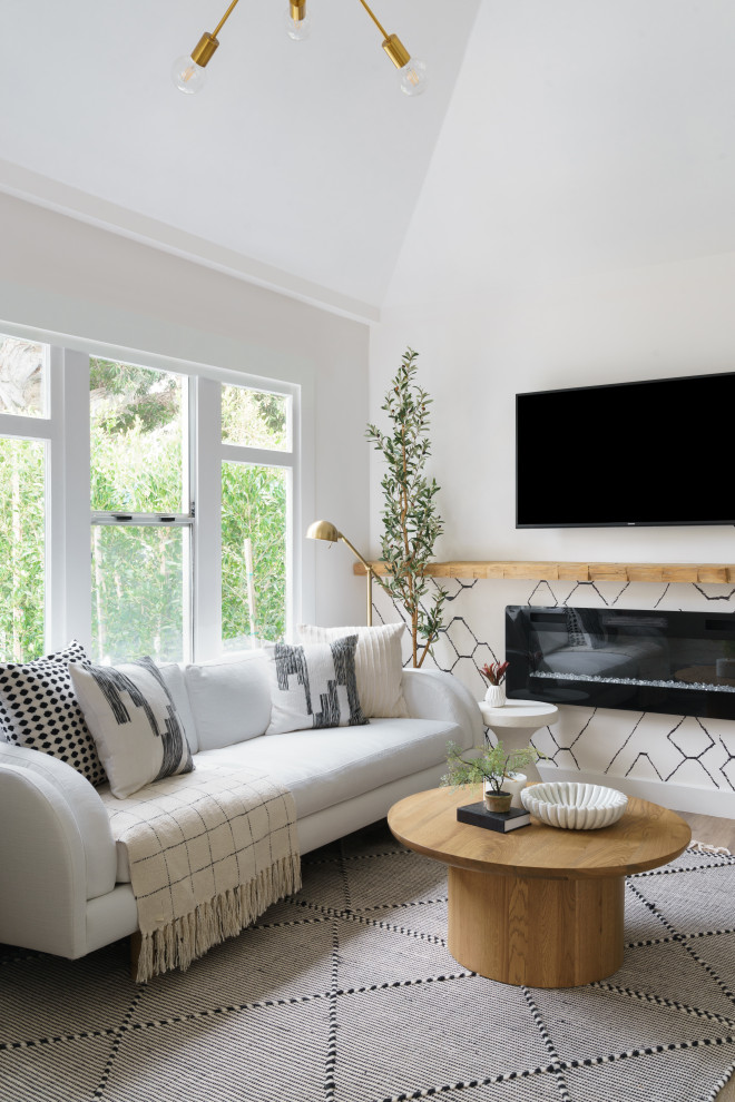 Стильный дизайн: маленькая открытая гостиная комната в стиле фьюжн с белыми стенами, полом из ламината, подвесным камином, телевизором на стене, коричневым полом и сводчатым потолком для на участке и в саду - последний тренд